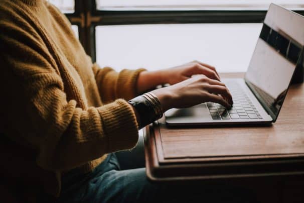 Person in yellow shirt using laptop