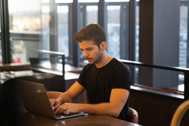 man in black shirt working on laptop