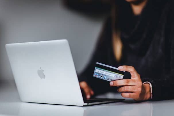 woman paying with card on macbook